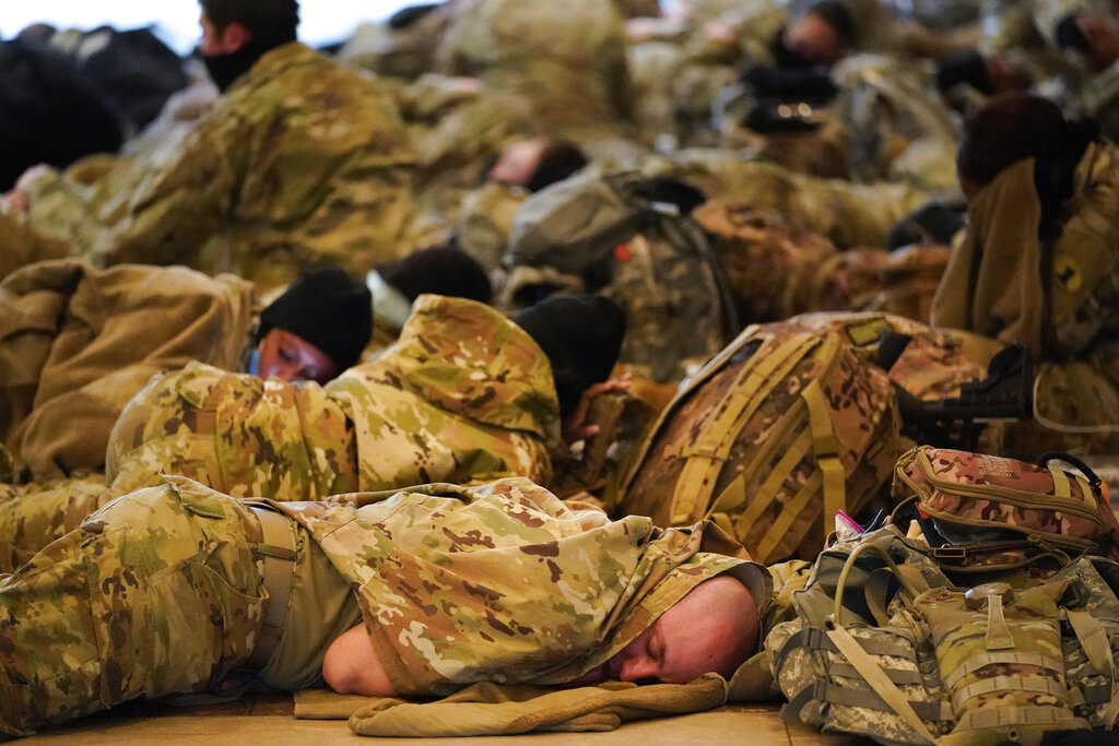 Troops rest as they hold inside the Capitol Visitor