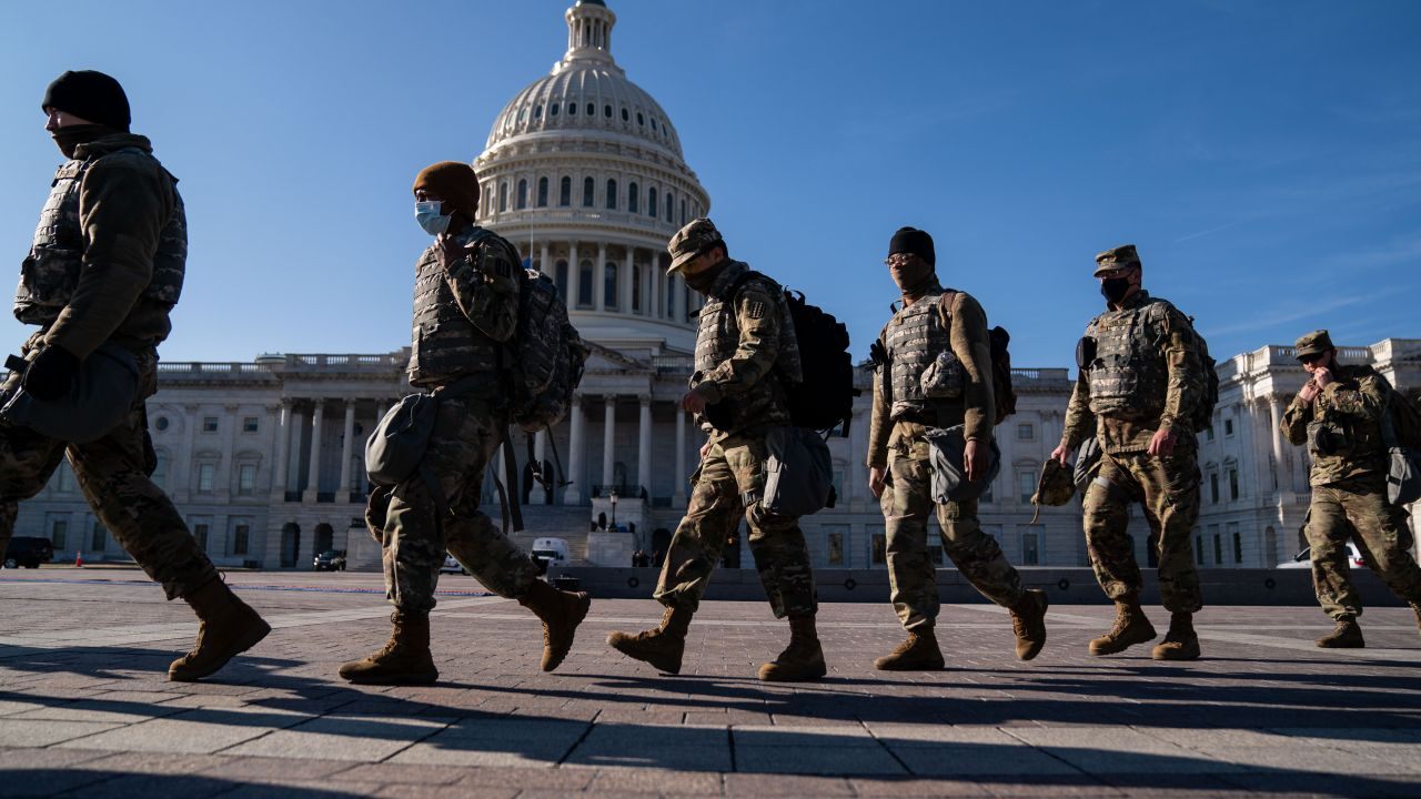 men in uniform marching in front of the US Capitol