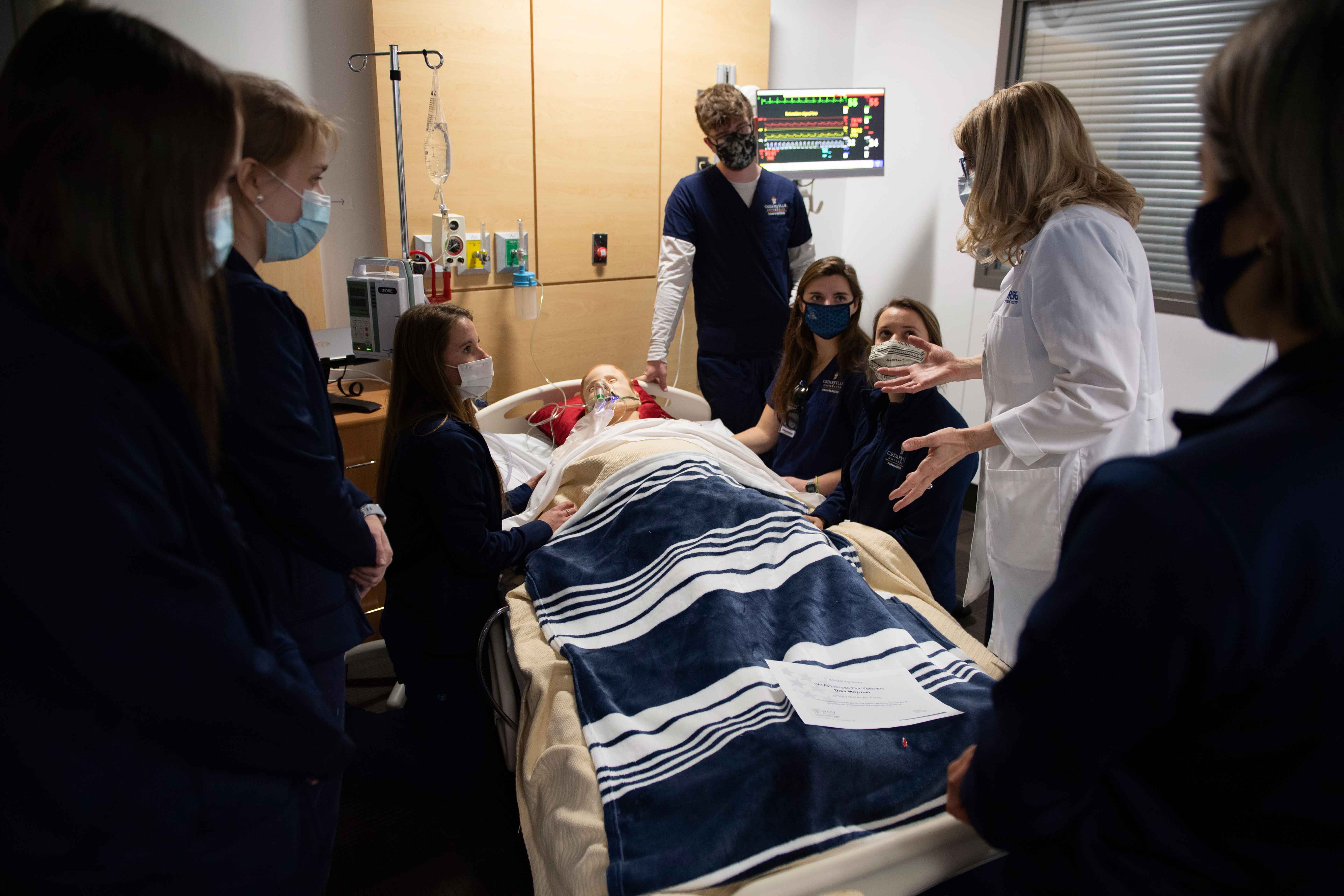 Dr. Beth Delaney from the Cedarville University School of Nursing, gives instructions to students participating in the simulator training