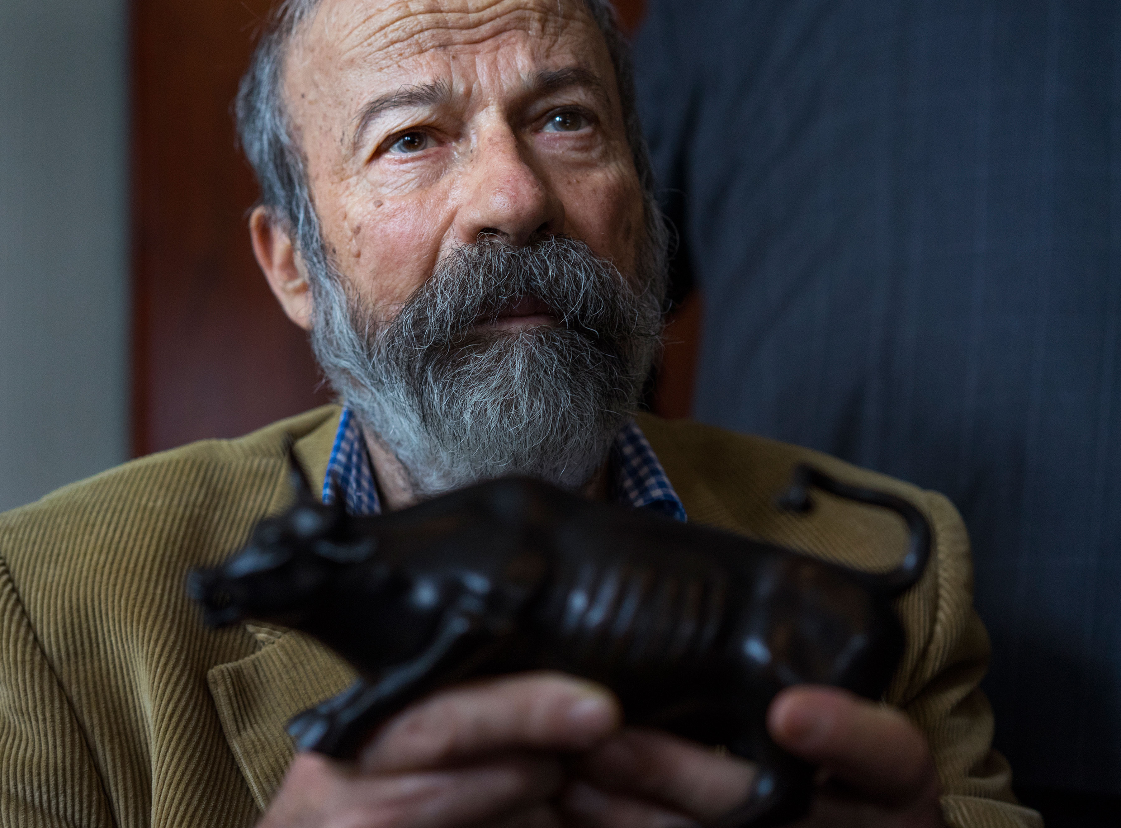 Arturo Di Modica holds a model of his Charging Bull sculpture