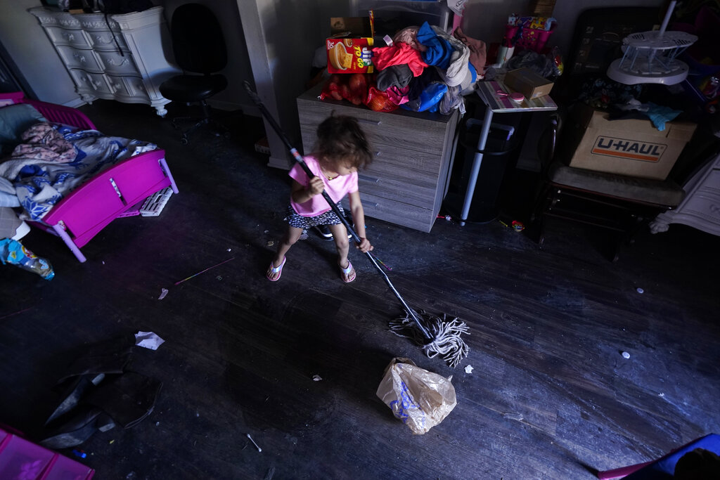 Raella Mills, 3, plays mop-up at her home in Dallas. Raella and her mother