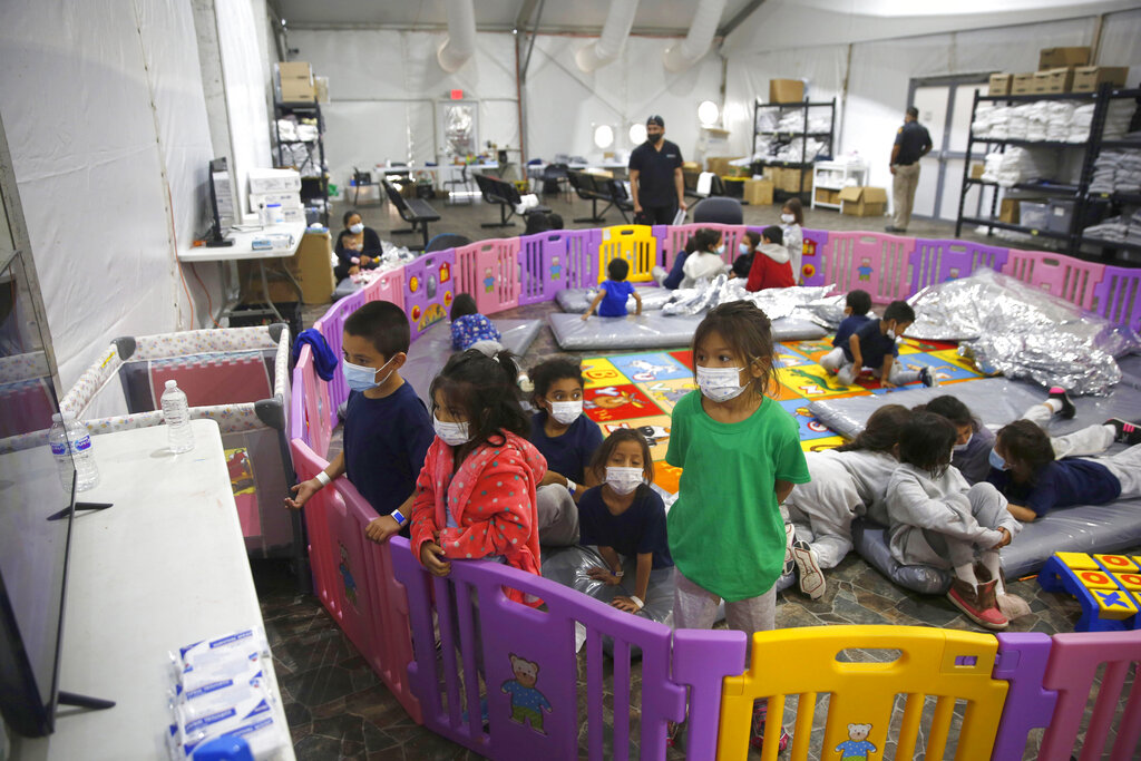 Young unaccompanied migrants, from ages 3 to 9, watch television inside a playpen at the U.S. Customs and Border Protection facility in Donna, Texas