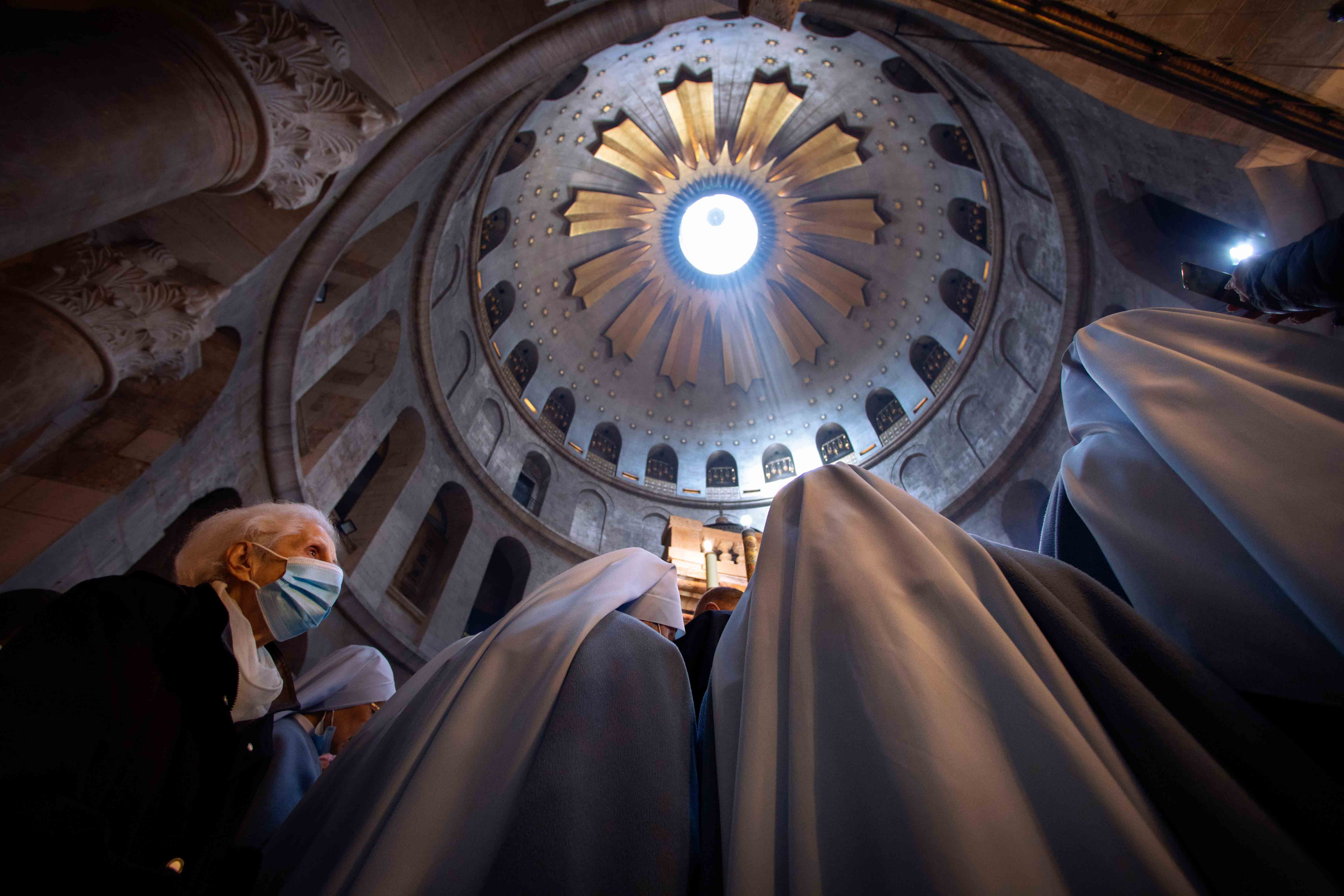 A woman wearing a face mask attends Easter Sunday Mass led by Latin Patriarch of Jerusalem Pierbattista Pizzaballa at the Church of the Holy Sepulchre, in the Old City of Jerusalem, Sunday, April 4, 2021.