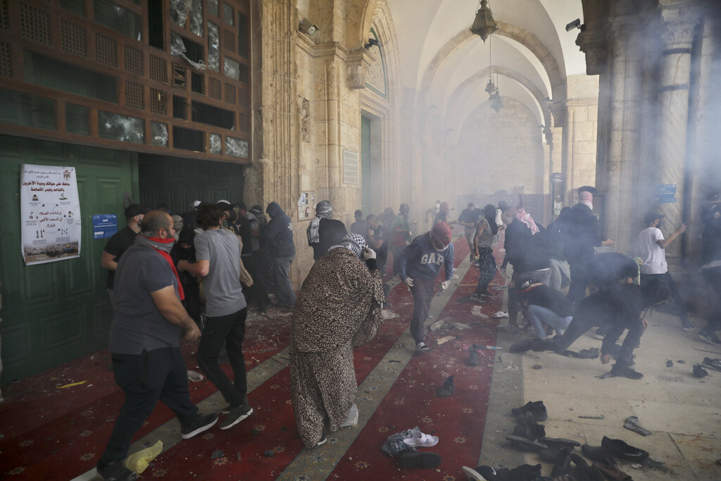 Palestinians inside the Al-Aqsa mosque clash with Israeli security forces at the Al Aqsa Mosque compound in Jerusalem