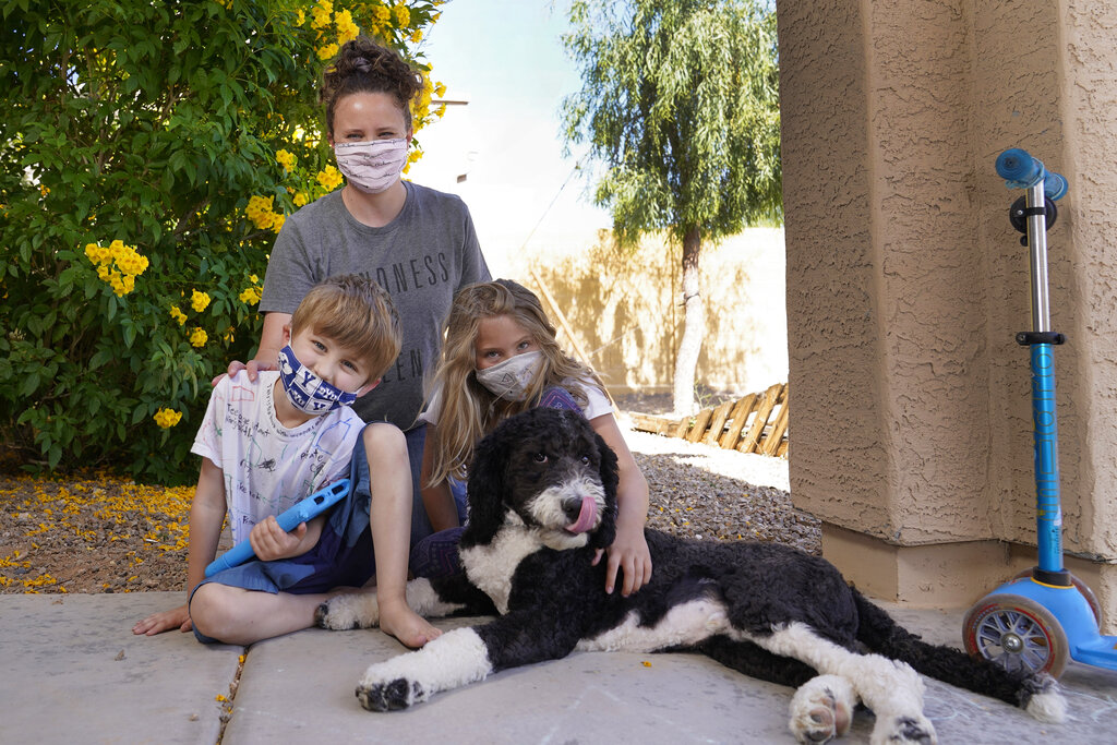Christie Black, middle, with her two children, Angela and Luke, left, and the family dog Teddy, pose at their home in Mesa, Ariz. 