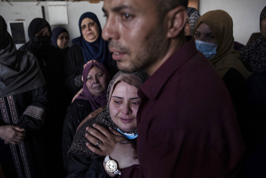Palestinian relatives mourn over four brothers from the Tanani family who were found under the rubble of a destroyed house following Israeli airstrikes in Beit Lahiya, northern Gaza Strip