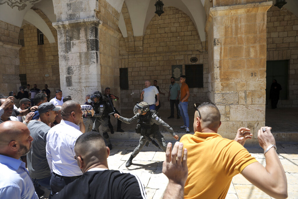 Israeli border police swing their batons at Muslim worshippers to prevent them from gathering for Friday prayers at the Dome of the Rock Mosque in the Al-Aqsa Mosque compound in the Old City of Jerusalem