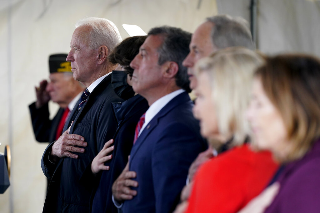 President Joe Biden stands as a rendition of the national anthem is performed during a Memorial Day event at Veterans Memorial Park at the Delaware Memorial Bridge in New Castle, Del.