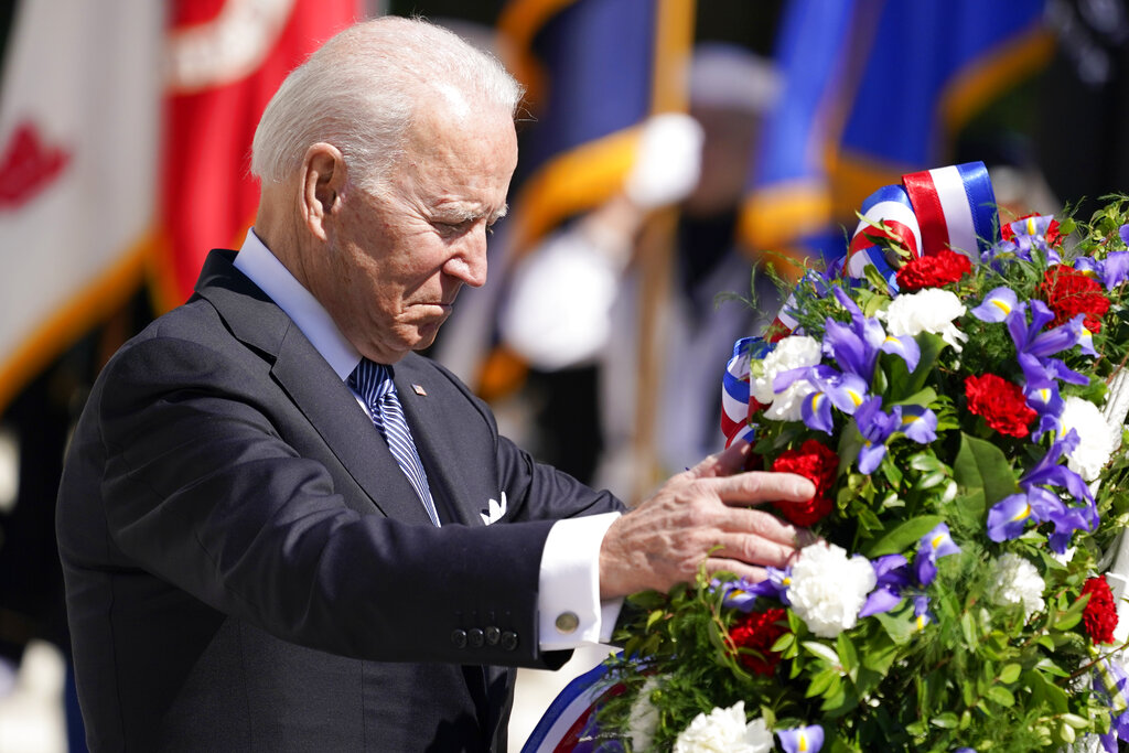 President Joe Biden adjusts a the wreath at the Tomb of the Unknown Soldier at Arlington National Cemetery on Memorial Day, Monday, May 31, 2021, in Arlington, Va.