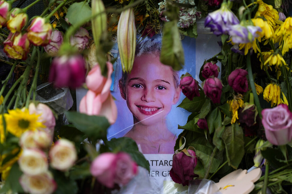 Flowers from well-wishers surround a photograph of Stella Cattarossi, age 7, on a makeshift memorial wall for the victims of the Champlain Towers South building collapse