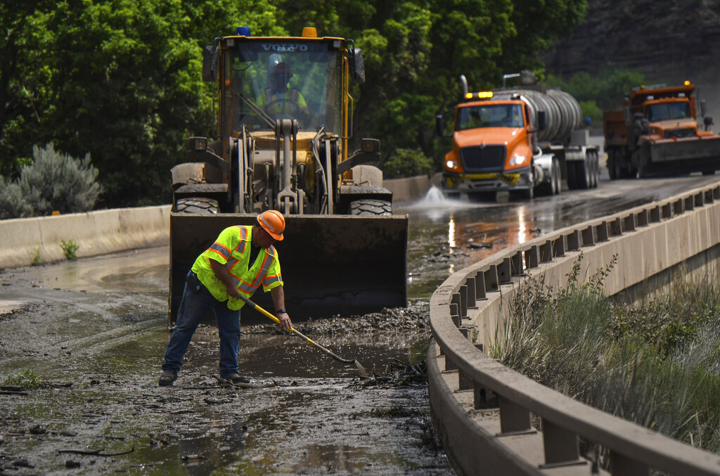 Colorado Department of Transportation crews work to clear mud and debris from the eastbound deck of Interstate 70 through Glenwood Canyon, Colo.