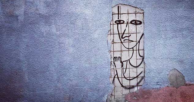 Mural on broken wall shows unhappy person behind bars