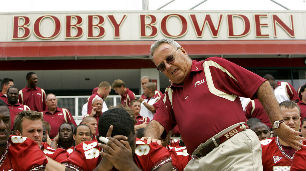 In this Aug. 12, 2007, file photo, Florida State head football coach Bobby Bowden, right, squeezes into his seat for a team photo during media day activities in Tallahassee, Fla. The Hall of Fame college football coach Bobby Bowden has died after a battle with pancreatic cancer. Exuding charm and wit, Bowden led Florida State to two national championships and a record of 315-98-4 during his 34 seasons with the Seminoles. In all, Bowden had 377 wins during his 40 years in major college coaching. He was 91 years old.