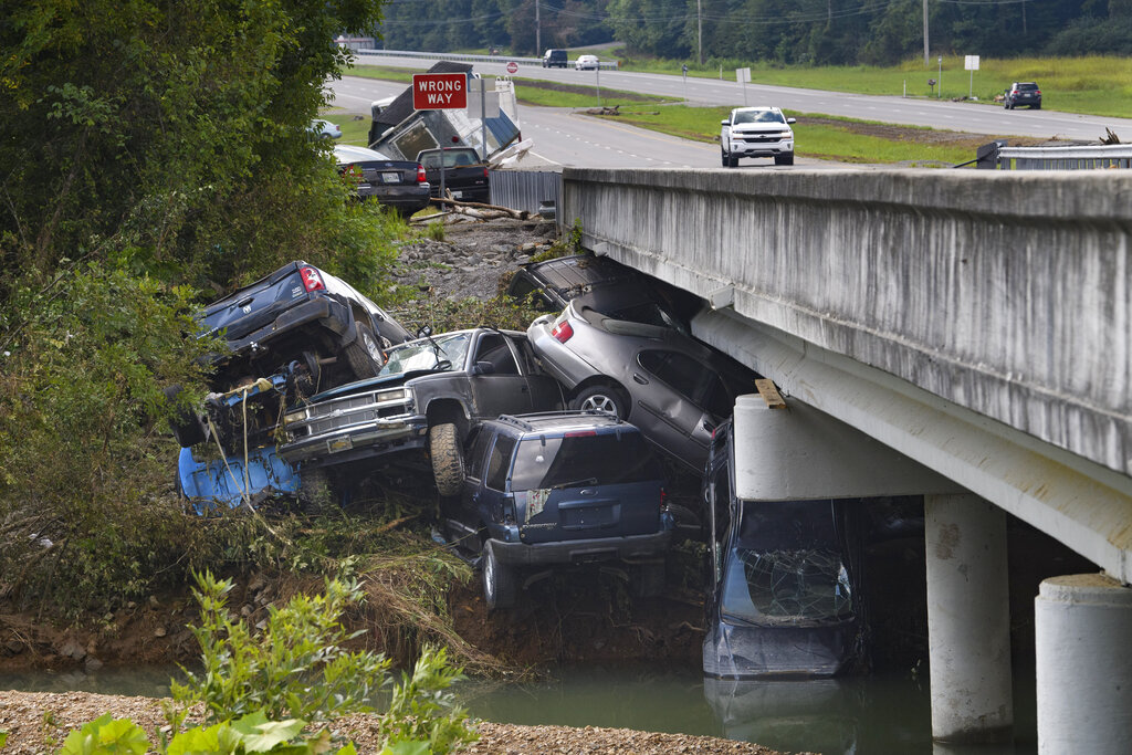 Cars are stacked on top of each other on the banks of Blue Creek being swept up in flood water, Monday in Waverly, Tenn. 