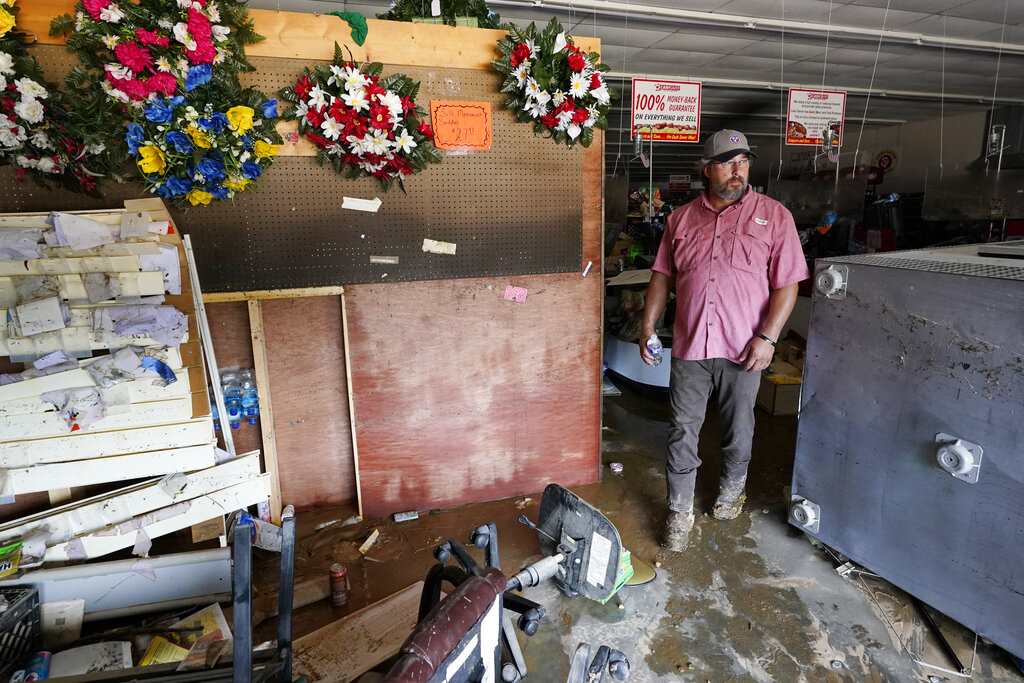 John Curtis, co-owner of Waverly Cash Saver grocery store, walks through his damaged store 