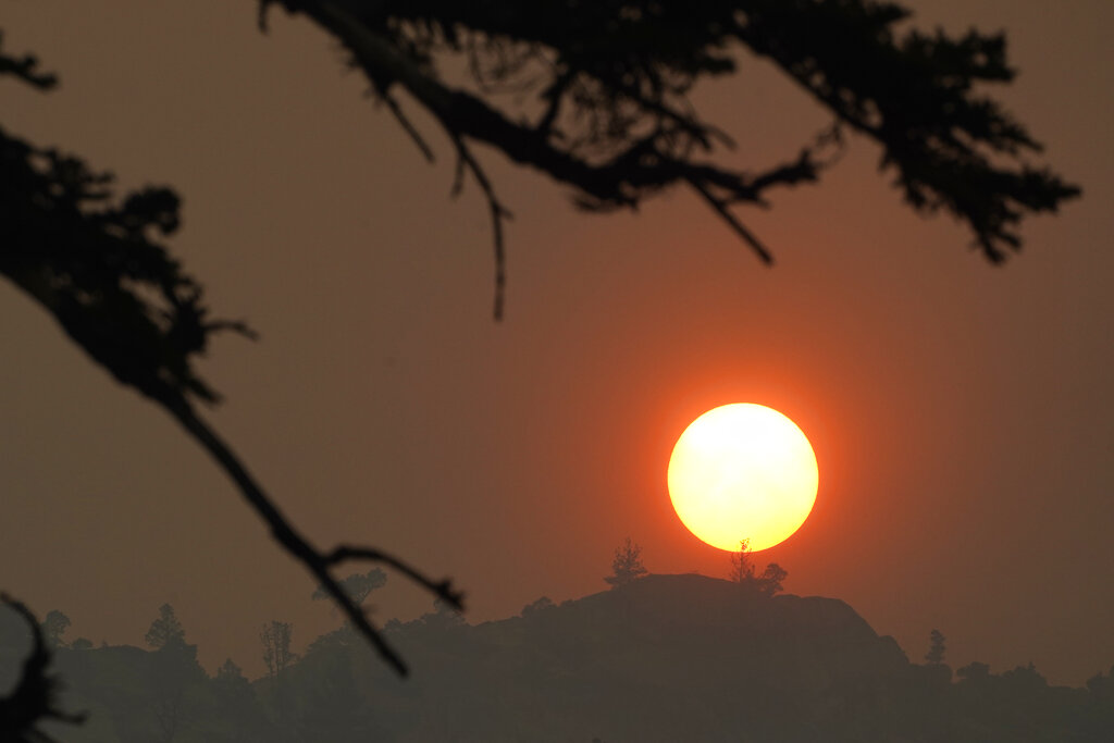 Smoke from the Caldor Fire obscures the sun as it sets over the mountains near South Lake Tahoe, Calif.