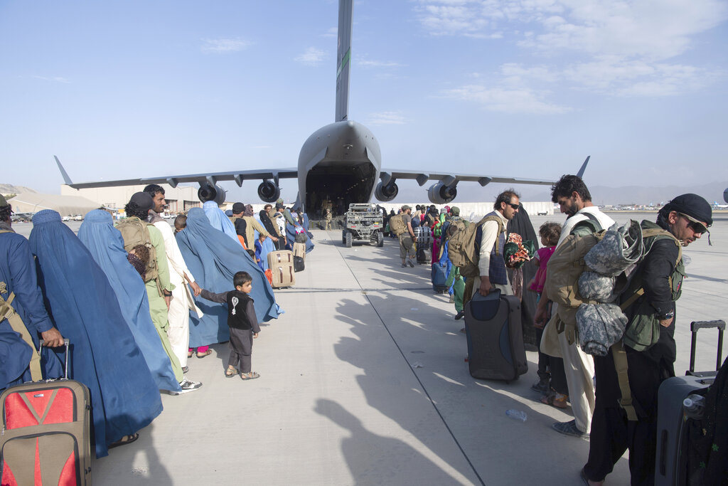 U.S. Air Force loadmasters and pilots assigned to the 816th Expeditionary Airlift Squadron, load people being evacuated from Afghanistan onto a U.S. Air Force C-17 Globemaster III at Hamid Karzai International Airport 