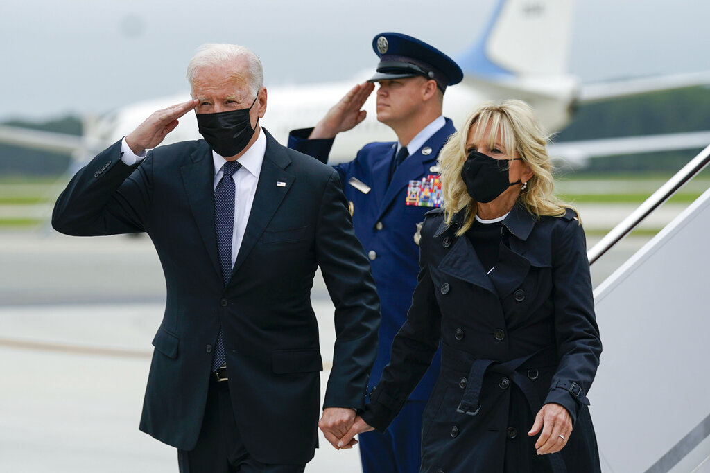 President Joe Biden returns a salute as he and first lady Jill Biden arrive at Dover Air Force Base, Del., as service members remains arrive