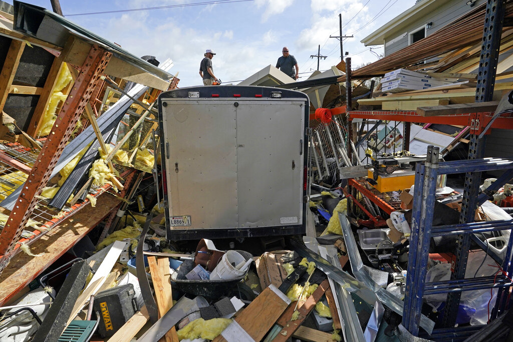 Jacob Hodges, right, and his brother Jeremy Hodges work to clear debris from their storage unit which was destroyed by Hurricane Ida