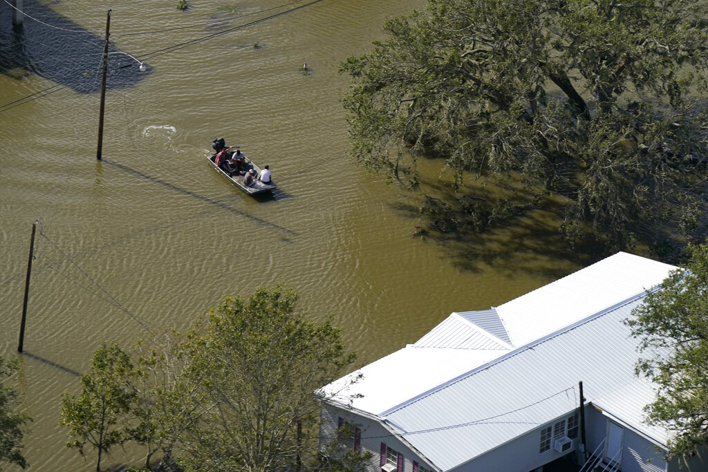 People move in boat on flooded street after Hurricane Ida
