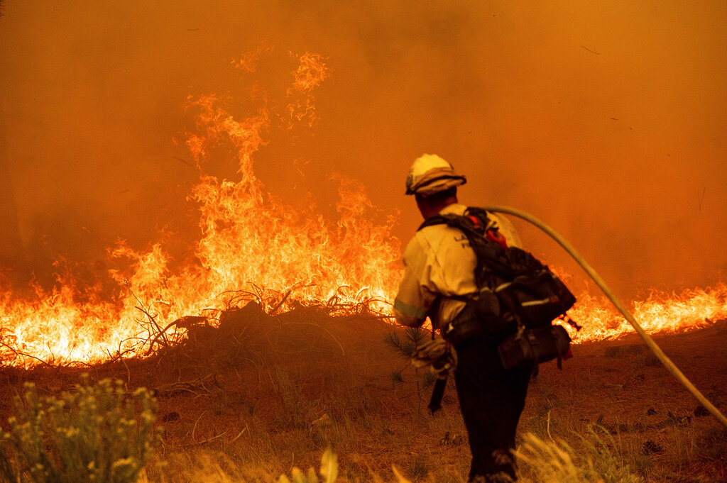 A firefighter battles the Caldor Fire along Highway 89