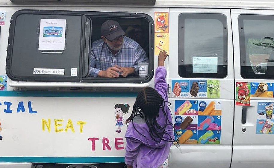 Child approaches window of Special Neat Treats Ice Cream Truck