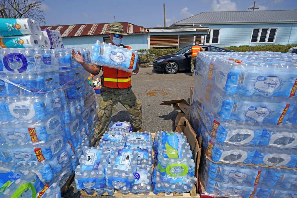 Louisiana National Guard Staff Sgt. Justin Dufreche helps load water into vehicles at a distribution site