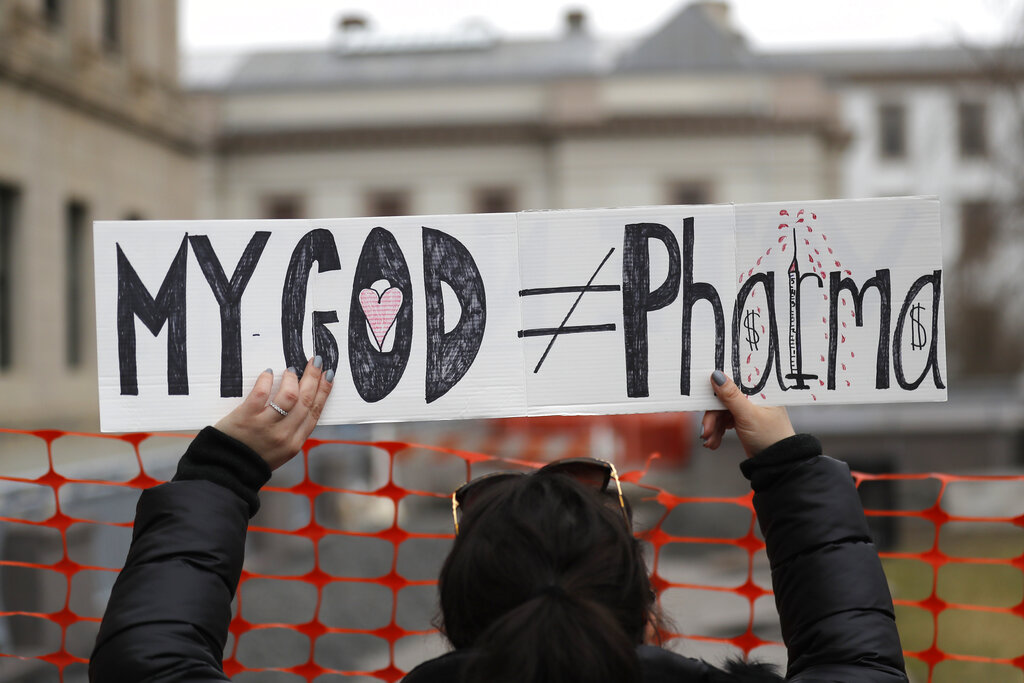 Woman holds a sign during a protest at the state house in Trenton, N.J.