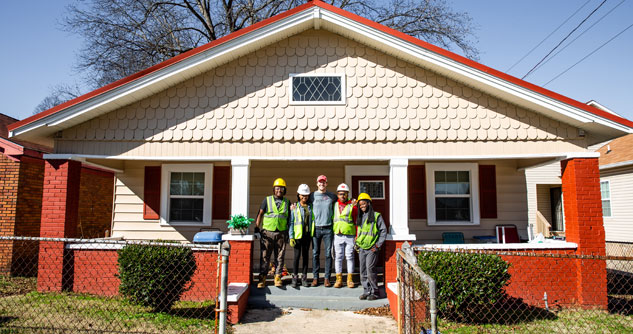 Kids and founder in front a of newly rebuilt home