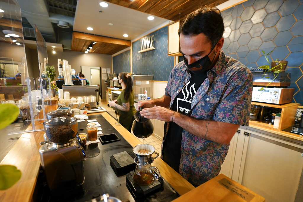 Chris Vigilante makes a dripped coffee for a customer at one of his coffee shops