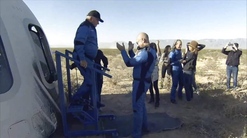 William Shatner exits the Blue Origin capsule as he is greeted by Jeff Bezos near Van Horn, Texas