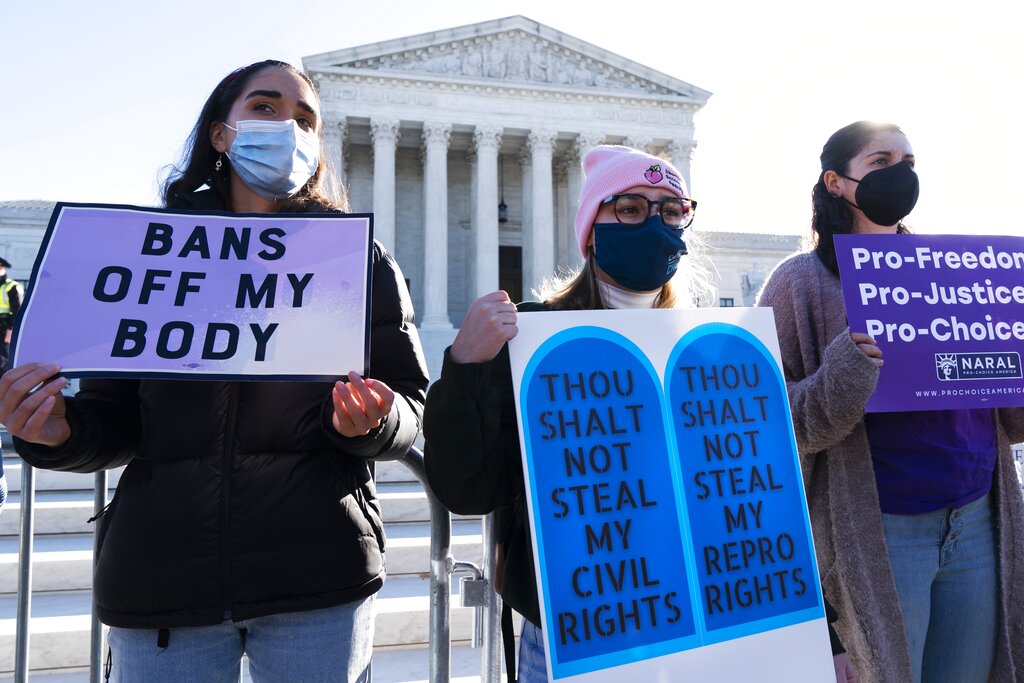 Caroline McDonald, left, a student at Georgetown University, Lauren Morrissey, with Catholics for Choice, and Pamela Huber, of Washington, join a pro-choice rally outside the Supreme Court