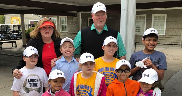 Man and woman surrounded with blind children at golf course