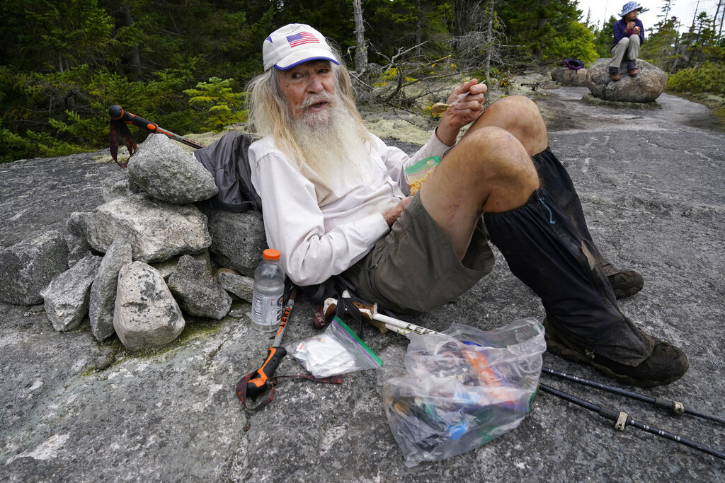 M.J. Eberhart, 83, scoops peanut butter out of a plastic bag during a lunch break on Mount Hayes on the Appalachian Trail,