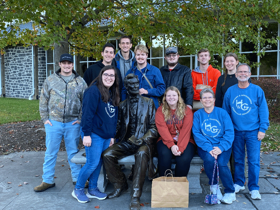 Dr. Sims, his nine students and his wife pose next to a statue of Lincoln in Gettysburg, Pennsylvania