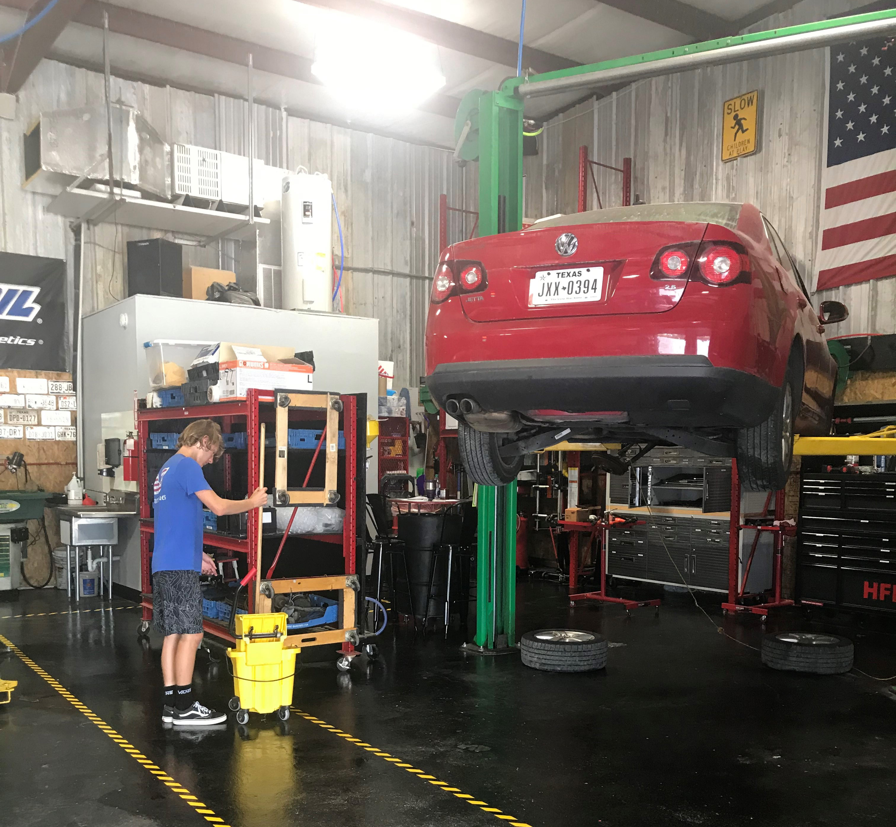 Volunteer mopping the floor of the auto repair shop God