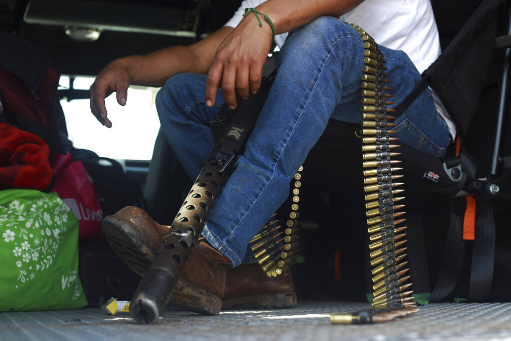 A member of the so-called self-defense group known as United Towns or Pueblos Unidos, sits with his ammunition during a rally in Nuevo Urecho, in the Mexican western state of Michoacan