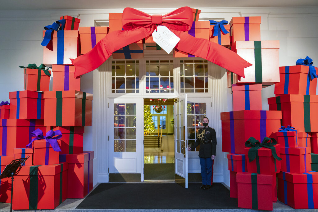 A Marine White House Military social aide holds the door to the East Wing entrance of the White House during a press preview of the White House holiday decorations