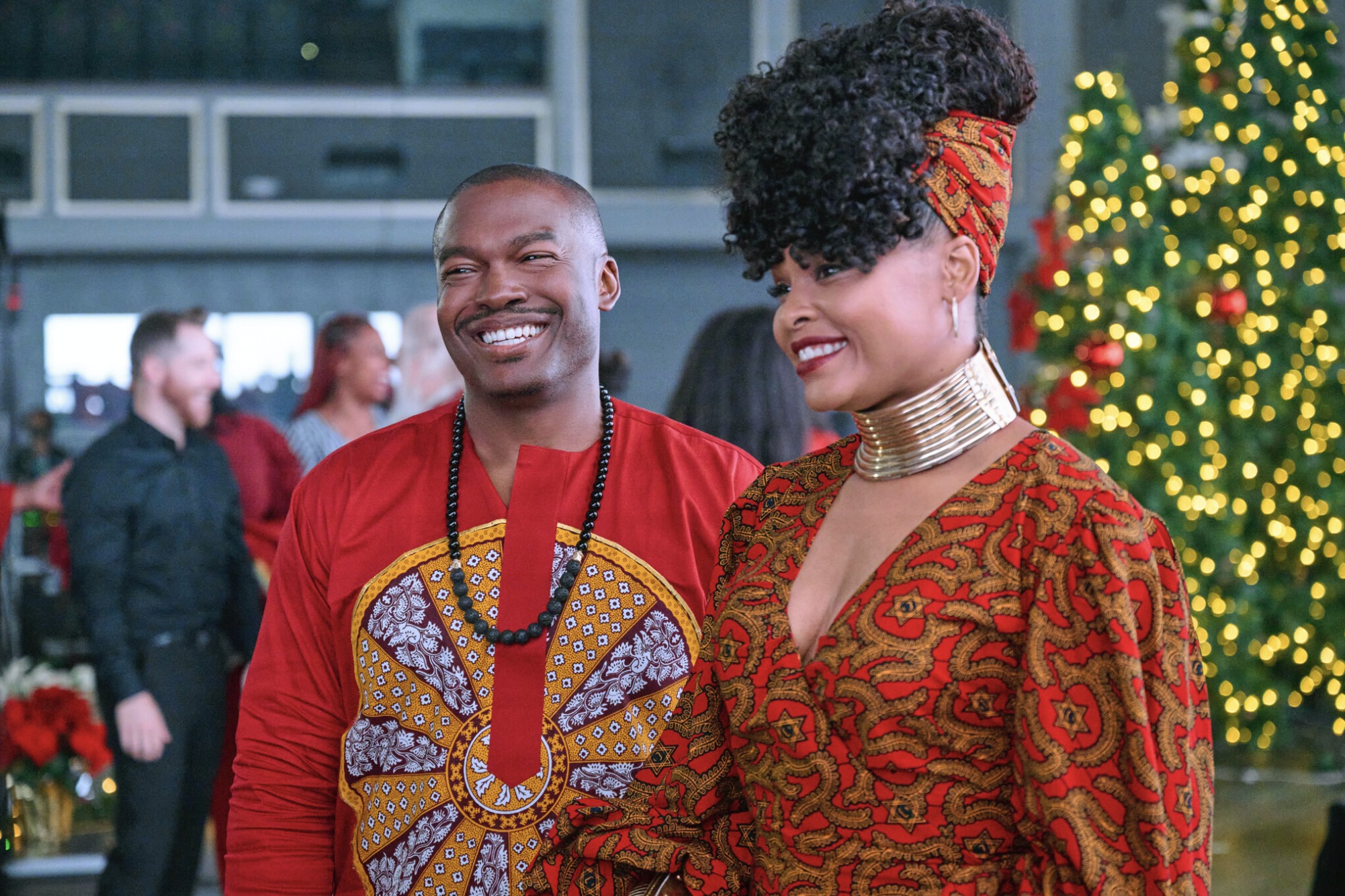 Two people in brightly colored African-inspired blouses