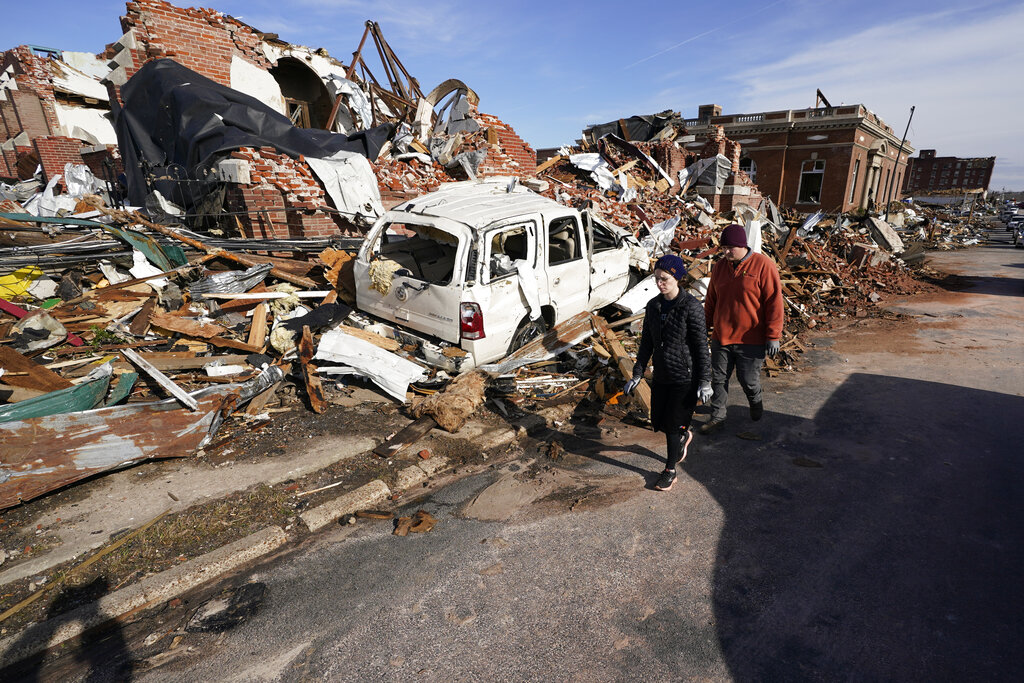 People survey damage from a tornado is seen in Mayfield, Ky.