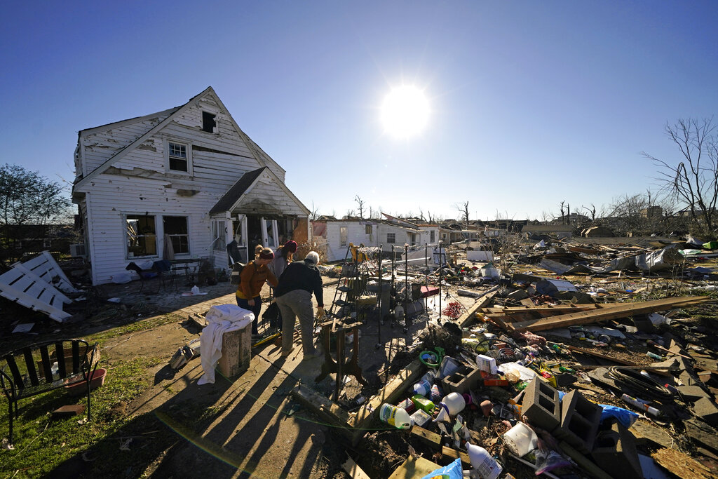 Volunteers, mostly employees from the Mayfield Consumer Products factory, help salvage possessions from the destroyed home of Martha Thomas, in the aftermath of tornadoes that tore through the region several days earlier, in Mayfield, Ky., Monday, Dec. 13, 2021