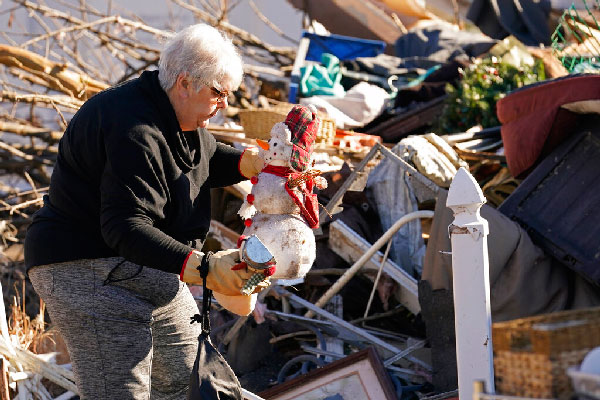 Martha Thomas salvages Christmas decorations from her destroyed home in the aftermath of tornadoes that tore through the region, in Mayfield, Ky.,