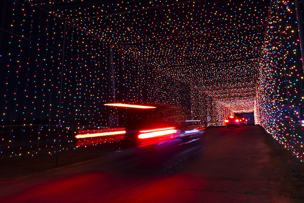 Car moving through Christmas light tunnel