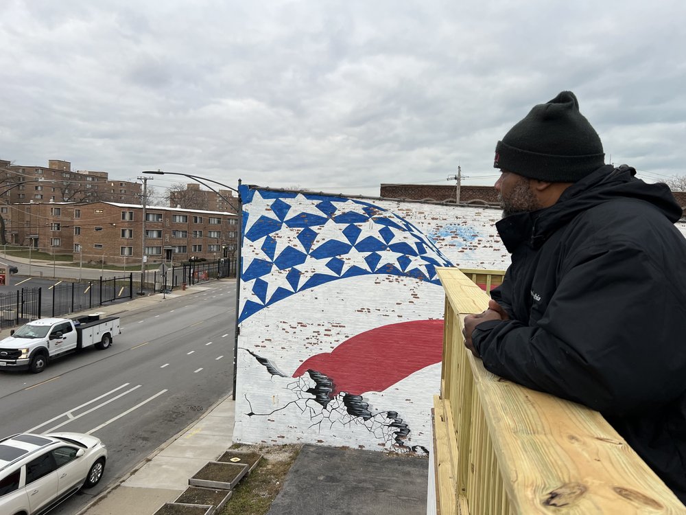 Pastor Corey Brooks looking down on street from top of storage containers