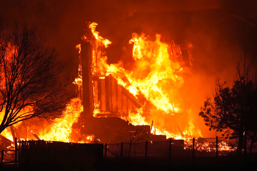 Homes burn as a wildfire rips through a development near Rock Creek Village near Broomfield, Colo.