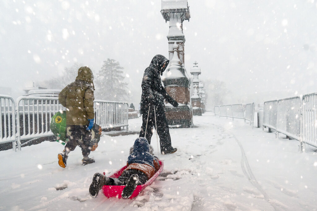 A kid is pulled on a sled as a winter storm delivers heavy snow to the Capitol in Washington