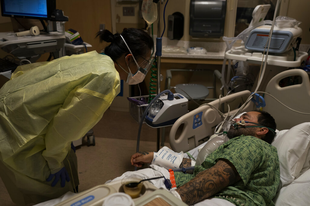 Registered nurse Emily Yu, left, talks to Paul Altamirano, a 50-year-old COVID-19 patient, at Providence Holy Cross Medical Center in Los Angeles