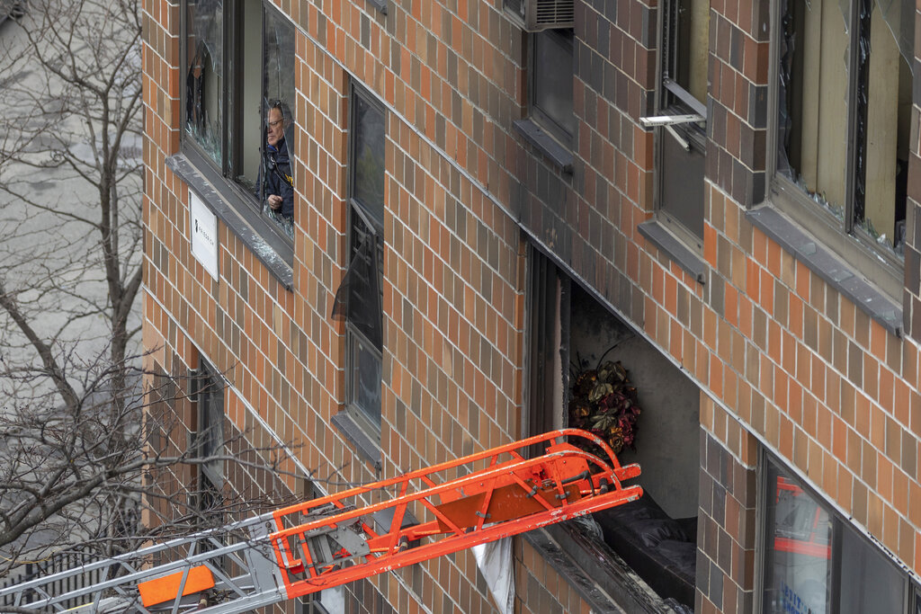 A ladder leads up to a window after a fatal fire at an apartment building in the Bronx