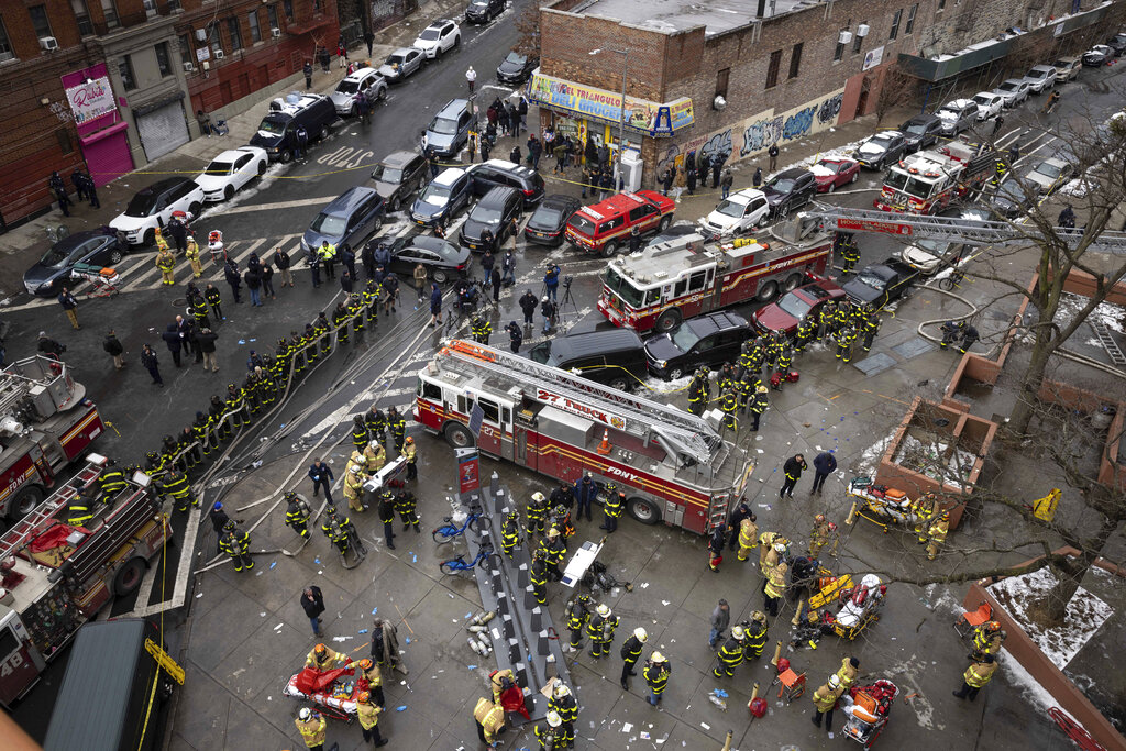 Firefighters work outside an apartment building after a fire in the Bronx