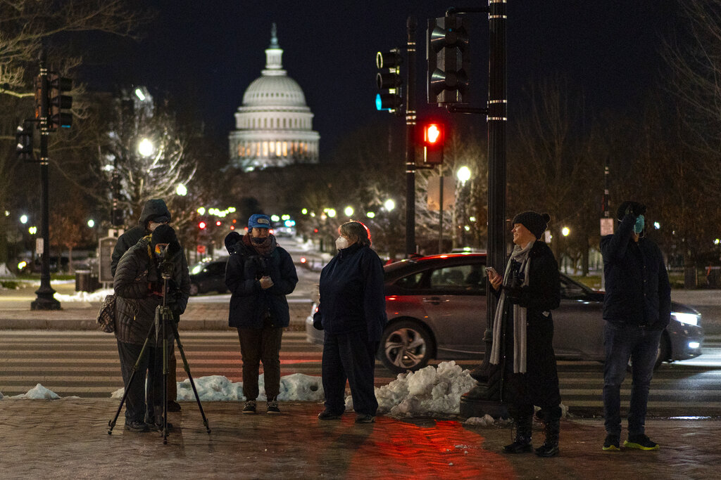 With the U.S. Capitol dome in the distance, birdwatchers line Columbus Circle in front of Union Station in Washington